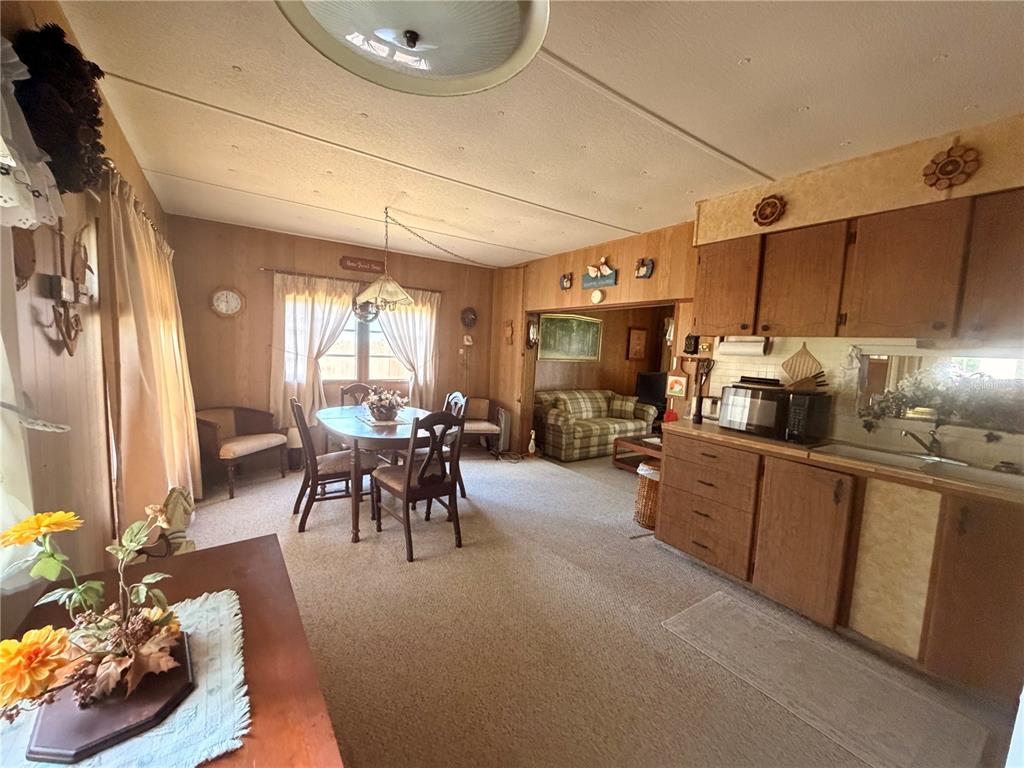 56340 Acorn Road Astor, FL 32102 - Photo 6 of 21 a kitchen with sink a counter and chairs