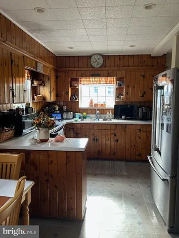 a kitchen with stainless steel appliances a sink a refrigerator and window