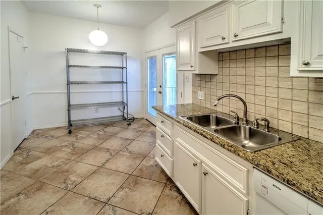 a kitchen with granite countertop a sink and a stove