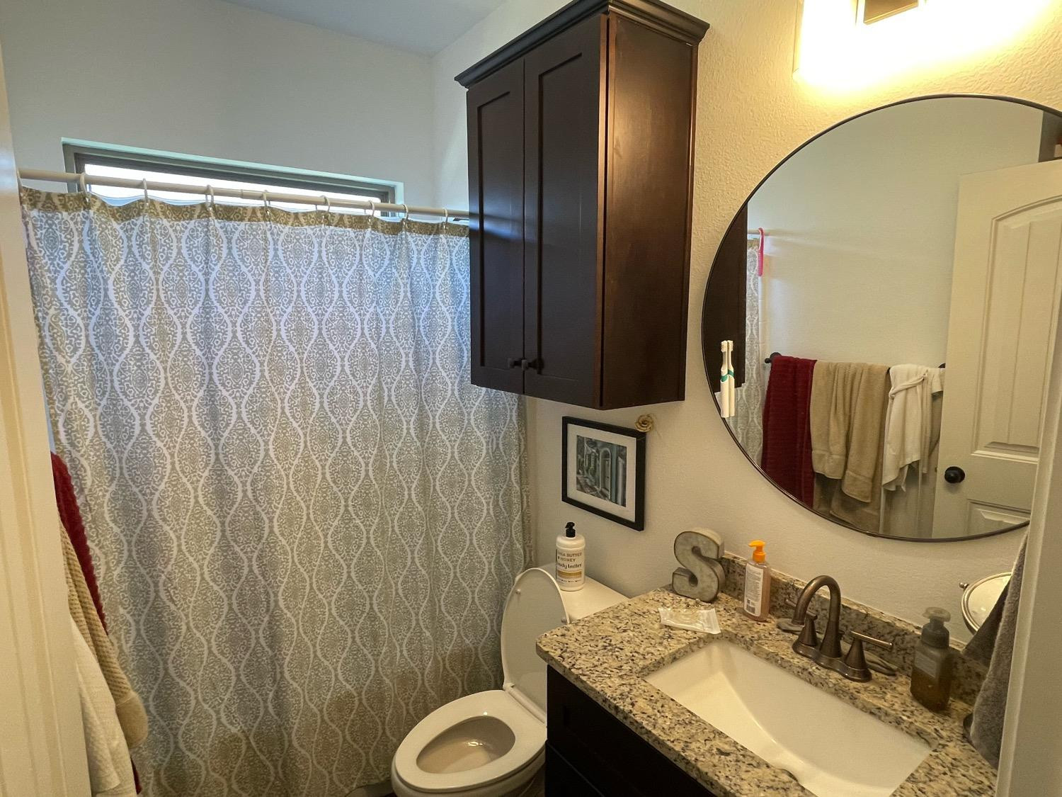 1707 100th Street Lubbock, TX 79423 - Photo 11 of 12 a bathroom with a granite countertop sink and a mirror