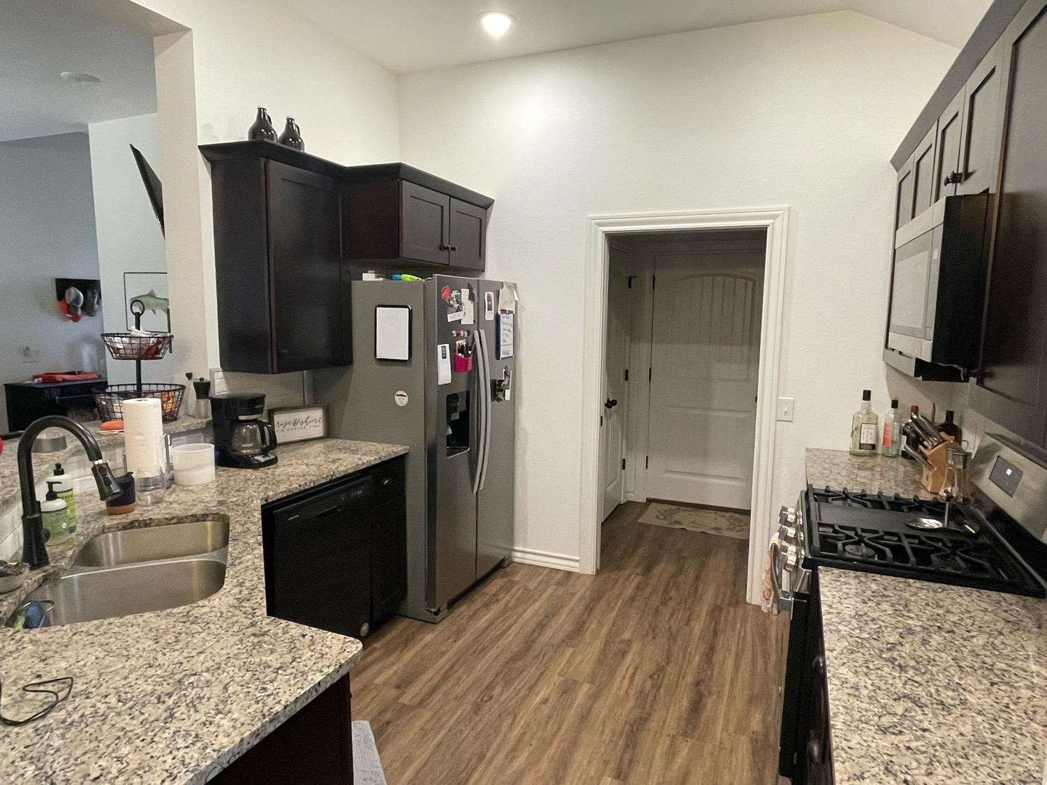 1707 100th Street Lubbock, TX 79423 - Photo 5 of 12 a kitchen with stainless steel appliances granite countertop a sink stove and refrigerator