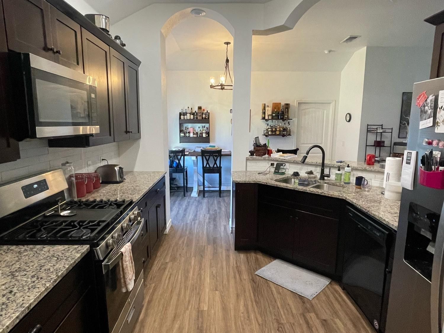 1707 100th Street Lubbock, TX 79423 - Photo 6 of 12 a kitchen with a sink stove and wooden floor