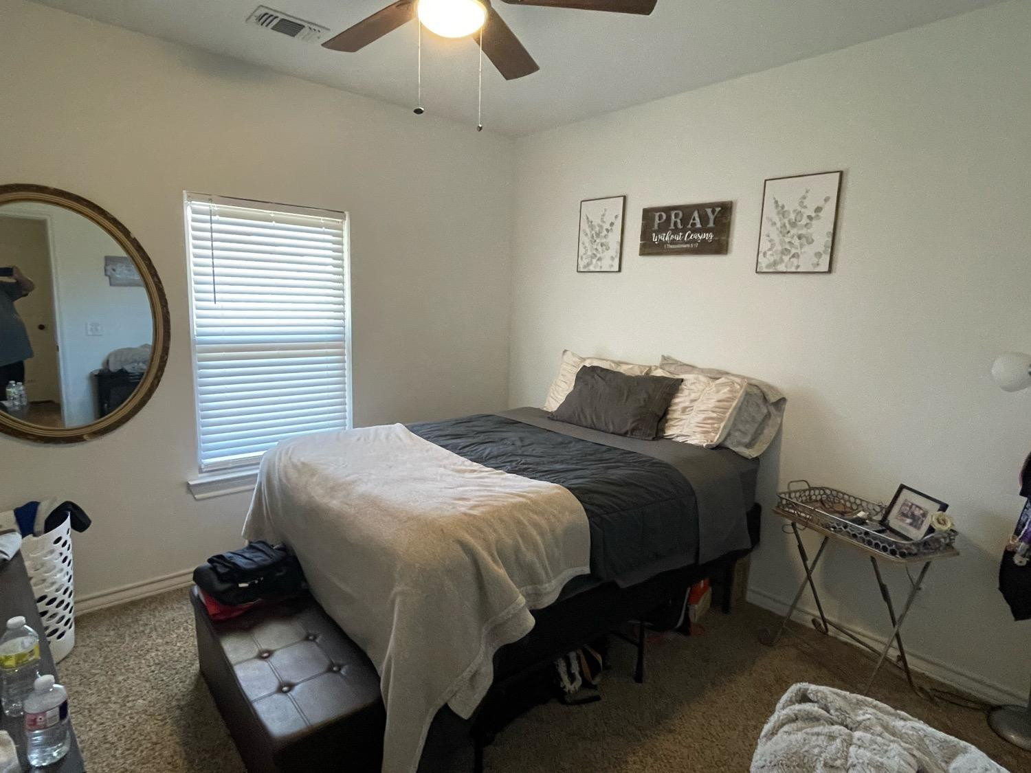 1707 100th Street Lubbock, TX 79423 - Photo 7 of 12 a bedroom with a bed and a mirror