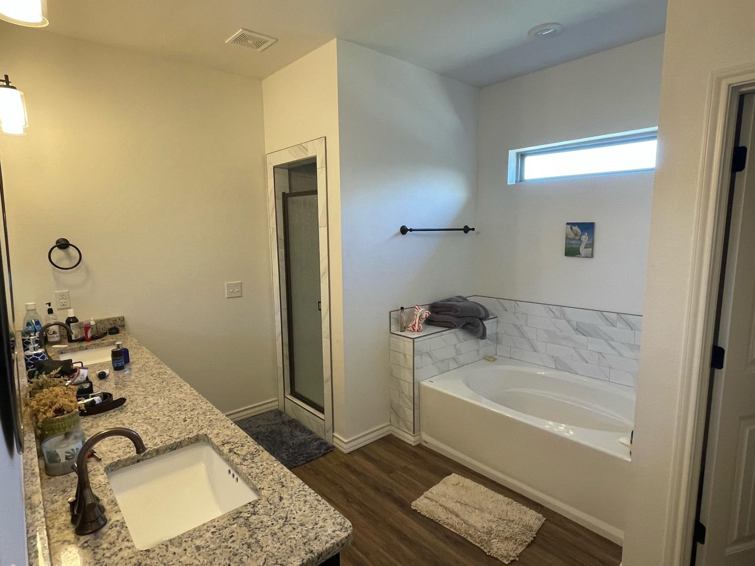 1707 100th Street Lubbock, TX 79423 - Photo 8 of 12 a bathroom with a granite countertop tub and a sink