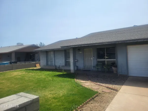 a view of a house with a yard and a table and chairs