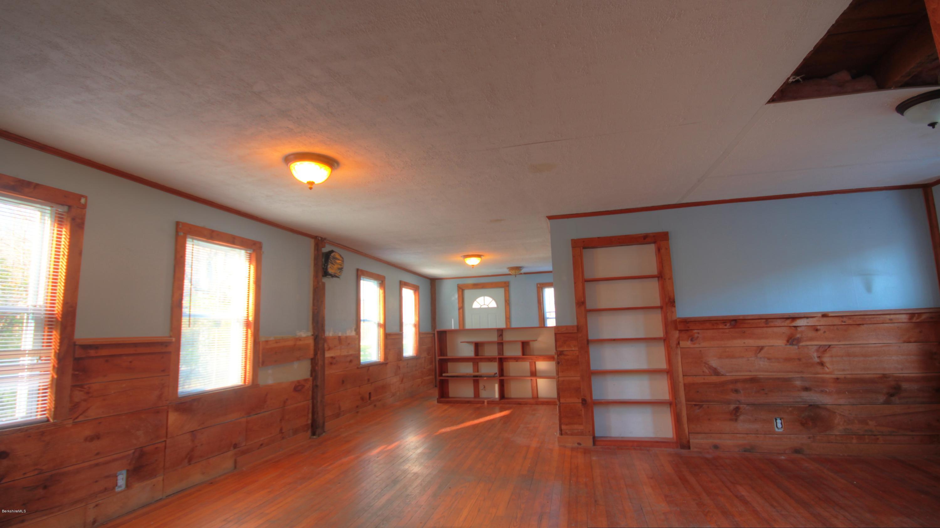 1458 Bancroft Road Becket, MA 01223 - Photo 5 of 19 a view of empty room with wooden floor and fan