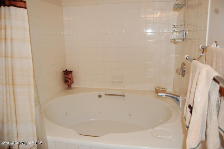 184 Fawn Road Pocono Lake, PA 18347 - Photo 13 of 23 a white bath tub sitting next to a white sink and vanity