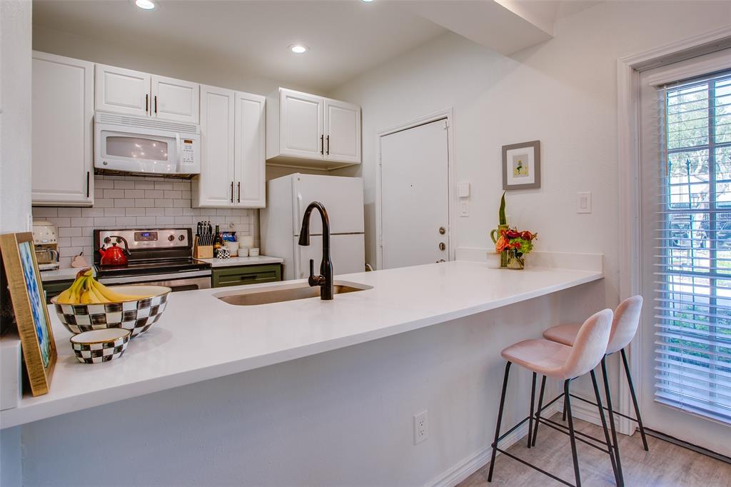 3105 San Jacinto Street, Unit 104 Dallas, TX 75204 - Photo 13 of 36 a kitchen with stainless steel appliances a sink a stove and white cabinets