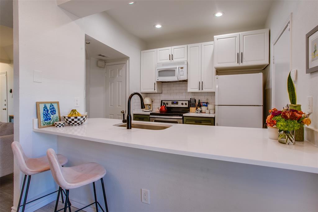 3105 San Jacinto Street, Unit 104 Dallas, TX 75204 - Photo 14 of 36 a kitchen with refrigerator and chairs