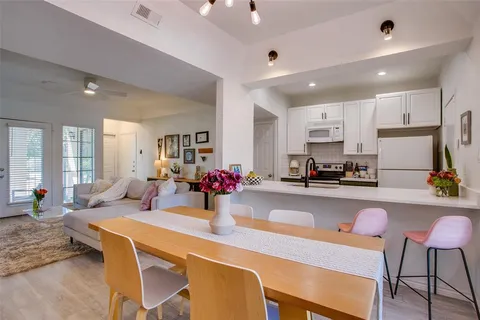 a kitchen with a dining table chairs and refrigerator