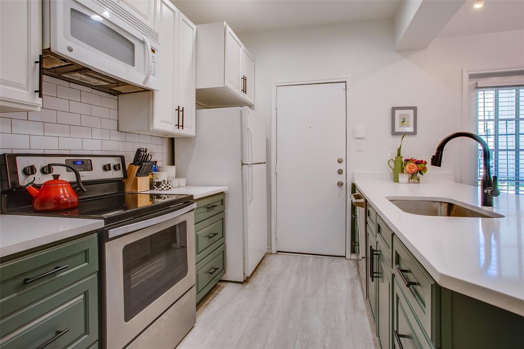 3105 San Jacinto Street, Unit 104 Dallas, TX 75204 - Photo 16 of 36 a kitchen with stainless steel appliances granite countertop a stove a sink and a refrigerator