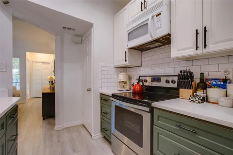 a kitchen with stainless steel appliances a stove and cabinets