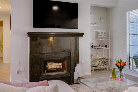 a living room with a fireplace and a flat screen tv