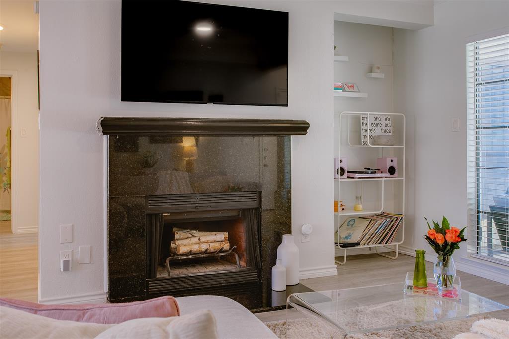 3105 San Jacinto Street, Unit 104 Dallas, TX 75204 - Photo 4 of 36 a living room with a fireplace and a flat screen tv