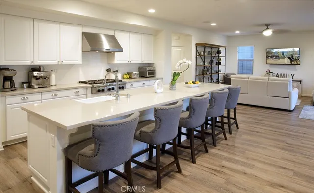 a kitchen with stainless steel appliances a sink a stove a table and chairs