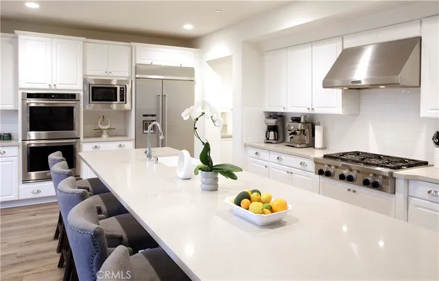 a kitchen with stainless steel appliances a stove a sink and a refrigerator