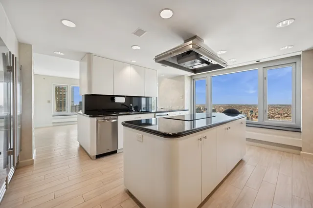 a kitchen with stainless steel appliances granite countertop a sink dishwasher a refrigerator and microwave with wooden floor