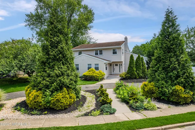 a front view of a house with a yard and trees