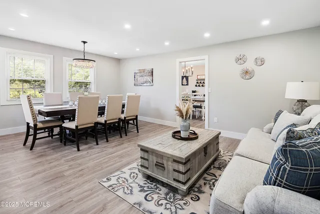 a kitchen with stainless steel appliances granite countertop a stove top oven a sink dishwasher a dining table and chairs with wooden floor