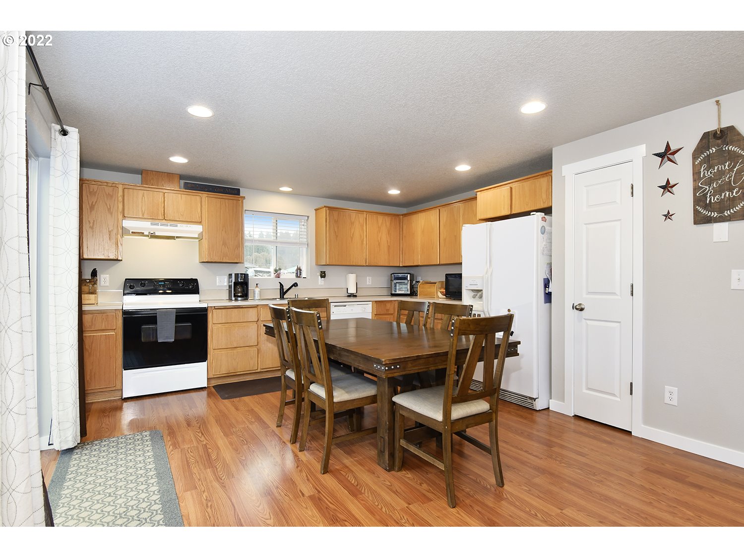 407 West Yacolt Road Yacolt, WA 98675 - Photo 7 of 21 a kitchen with stainless steel appliances kitchen island granite countertop a refrigerator a stove a sink dishwasher with a dining table and chairs with wooden floor