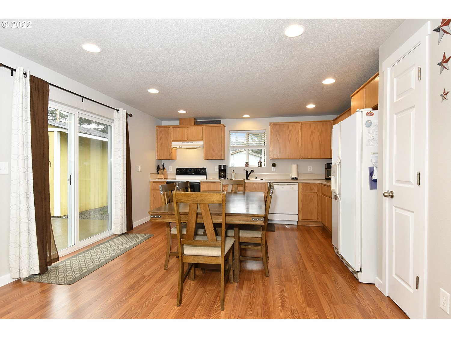 407 West Yacolt Road Yacolt, WA 98675 - Photo 8 of 21 a open kitchen with dining table wooden floor and a refrigerator