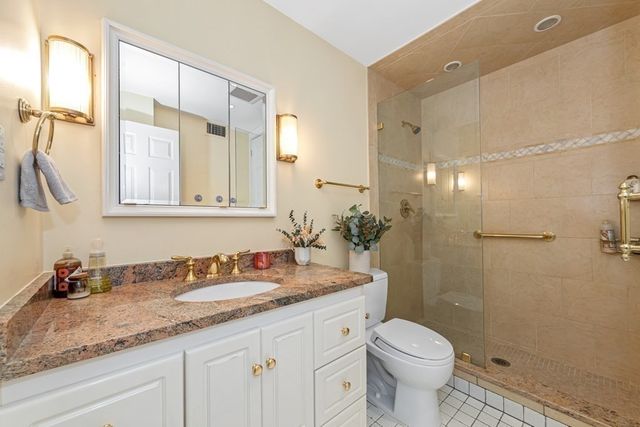 a bathroom with a granite countertop sink toilet and shower