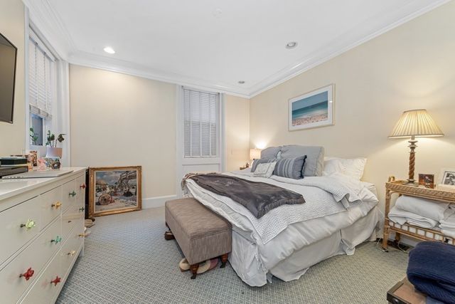 a spacious bedroom with a bed and dresser