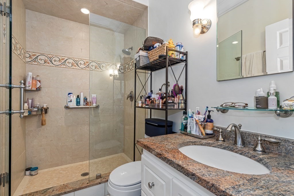3 Myrtle Street, Unit 1 Boston, MA 02114 - Photo 18 of 25 a bathroom with a granite countertop sink a toilet and shower