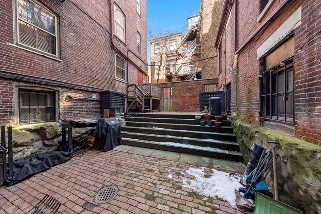 a backyard of a house with barbeque oven and furniture