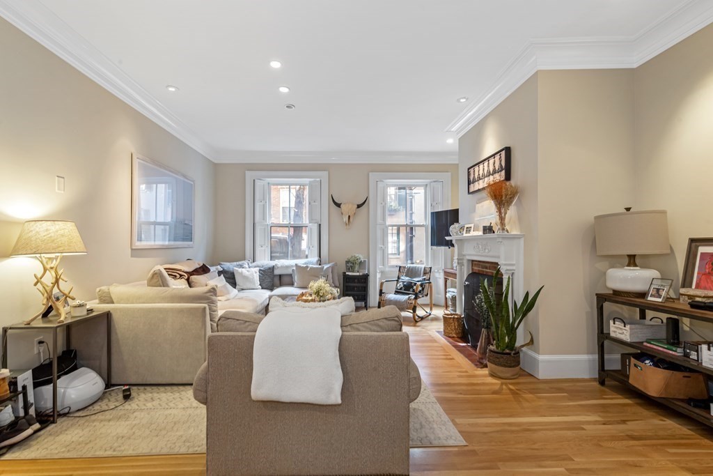 3 Myrtle Street, Unit 1 Boston, MA 02114 - Photo 3 of 25 a living room with furniture a fireplace a flat screen tv and a large window