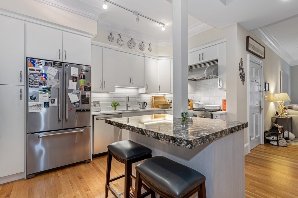 3 Myrtle Street, Unit 1 Boston, MA 02114 - Photo 6 of 25 a kitchen with stainless steel appliances granite countertop a refrigerator a stove and a sink with cabinets