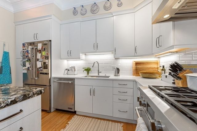 a kitchen with stainless steel appliances granite countertop a stove and a refrigerator