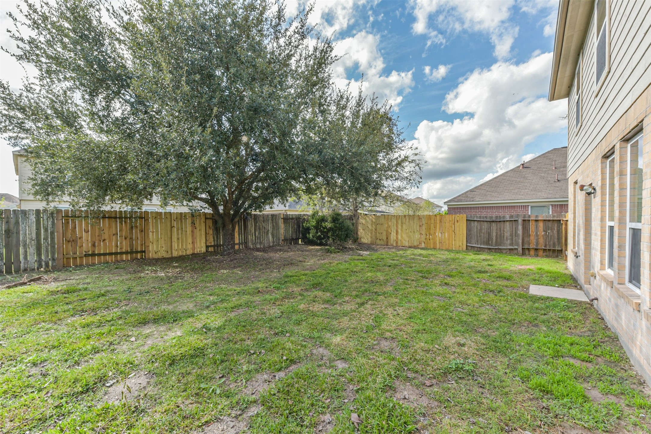 1810 Sun Point Court Humble, TX 77396 - Photo 37 of 38 a view of a backyard with large trees and wooden fence