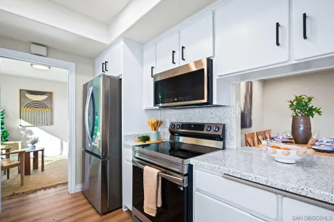 a large kitchen with stainless steel appliances granite countertop a lot of counter space and wooden floor