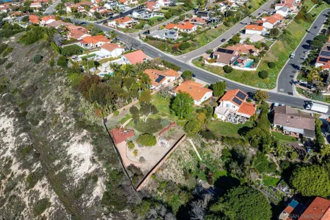 a view of a white house with a small yard and a garden