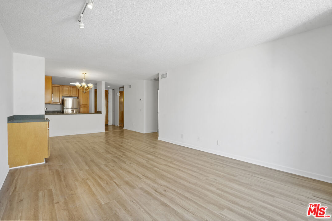 10751 Wilshire Boulevard, Unit PH 6 Los Angeles, CA 90024 - Photo 16 of 41 a view of a big room with wooden floor and a kitchen