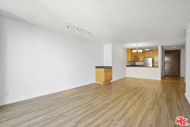 a view of a kitchen with wooden floor and front door