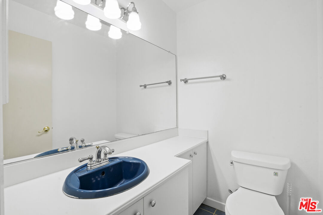 10751 Wilshire Boulevard, Unit PH 6 Los Angeles, CA 90024 - Photo 21 of 41 a bathroom with a sink a toilet and a mirror