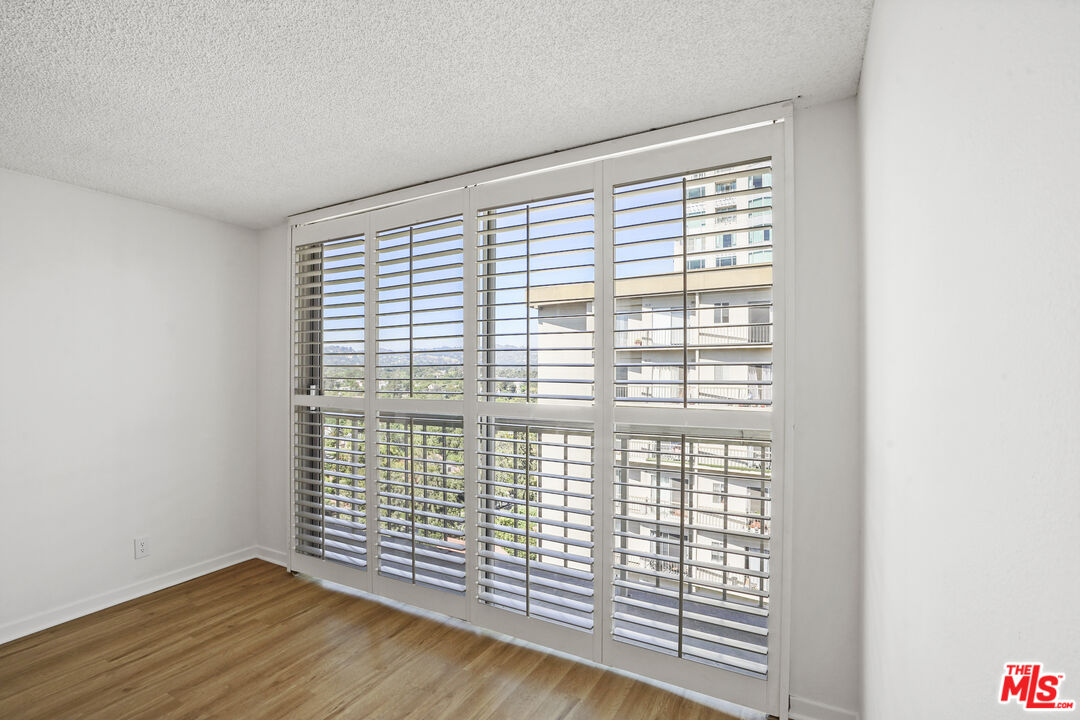 10751 Wilshire Boulevard, Unit PH 6 Los Angeles, CA 90024 - Photo 23 of 41 a view of an empty room with wooden floor and a window