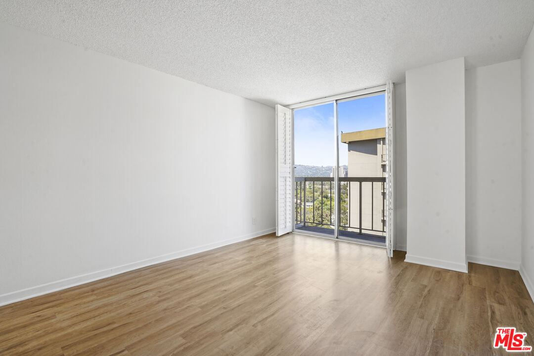 10751 Wilshire Boulevard, Unit PH 6 Los Angeles, CA 90024 - Photo 24 of 41 a view of an empty room with wooden floor and a window