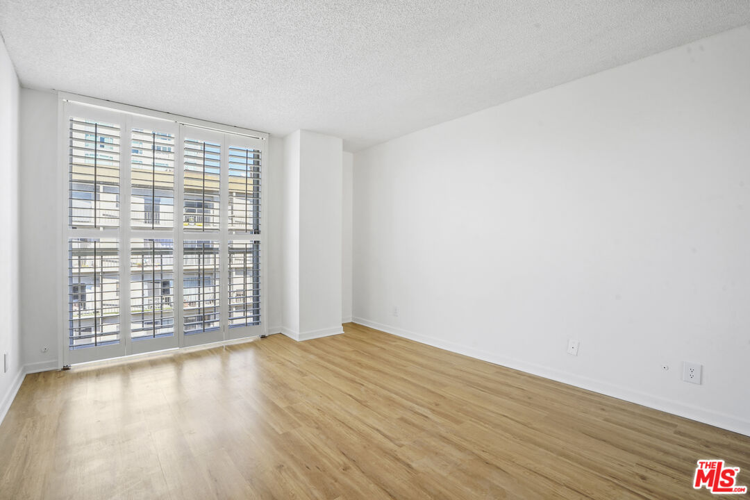 10751 Wilshire Boulevard, Unit PH 6 Los Angeles, CA 90024 - Photo 31 of 41 a view of an empty room with wooden floor and a window