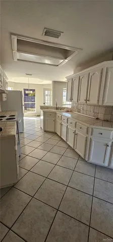 a kitchen with a sink a stove and cabinets