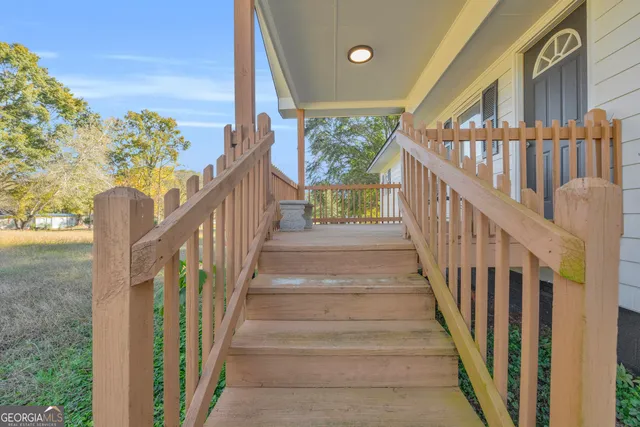 a view of staircase with lots of frames on wall and a large window