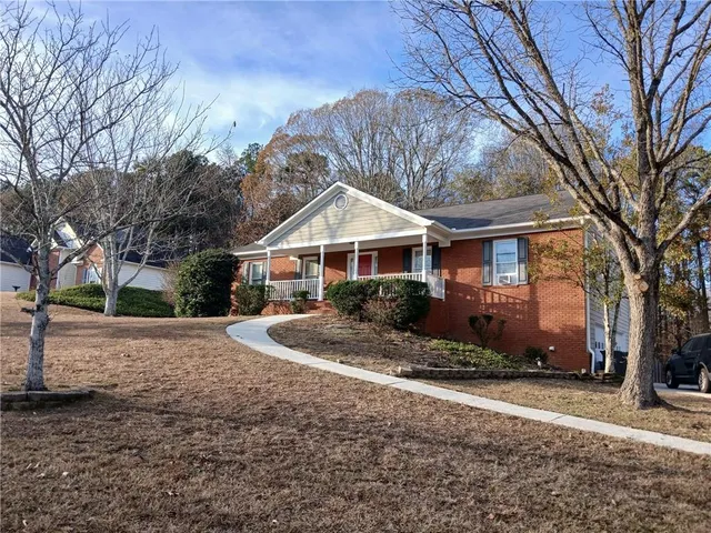 a front view of house with yard and trees around