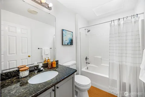 a bathroom with a granite countertop sink toilet and shower