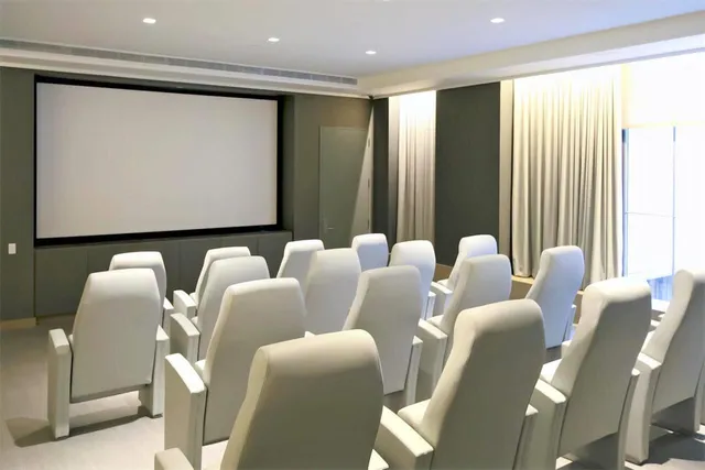 a media room with lots of chairs and a projector screen