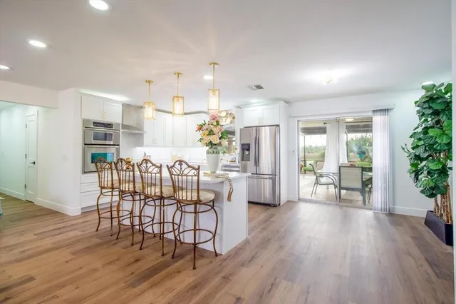 a large kitchen with stainless steel appliances a refrigerator and a sink
