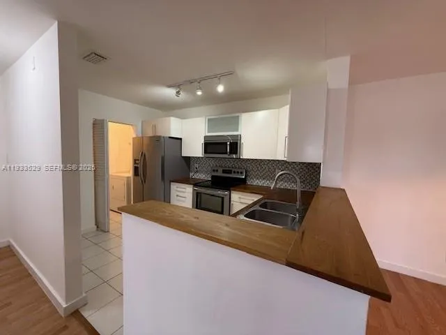 a kitchen with granite countertop a refrigerator and a stove top oven