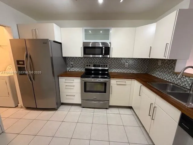 a kitchen with cabinets stainless steel appliances and counter space