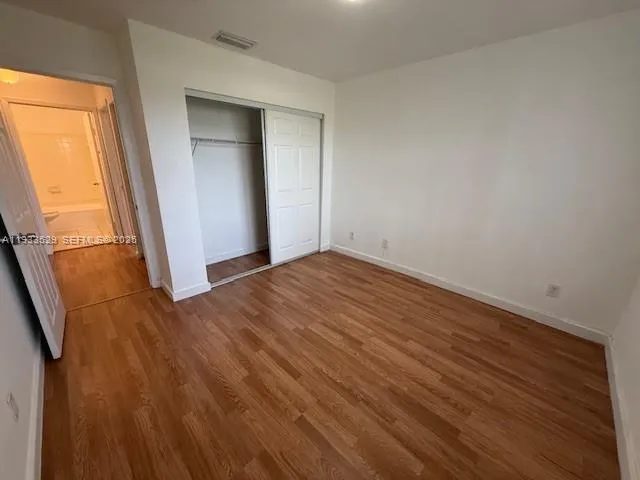 an empty room with wooden floor and sliding door
